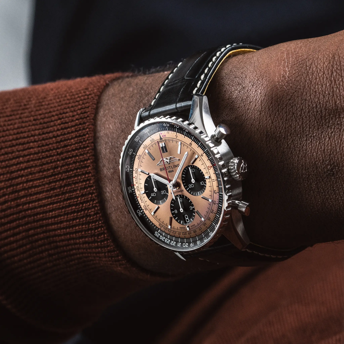 Breitling Navitimer chronograph copper dial watch worn on wrist with black leather strap