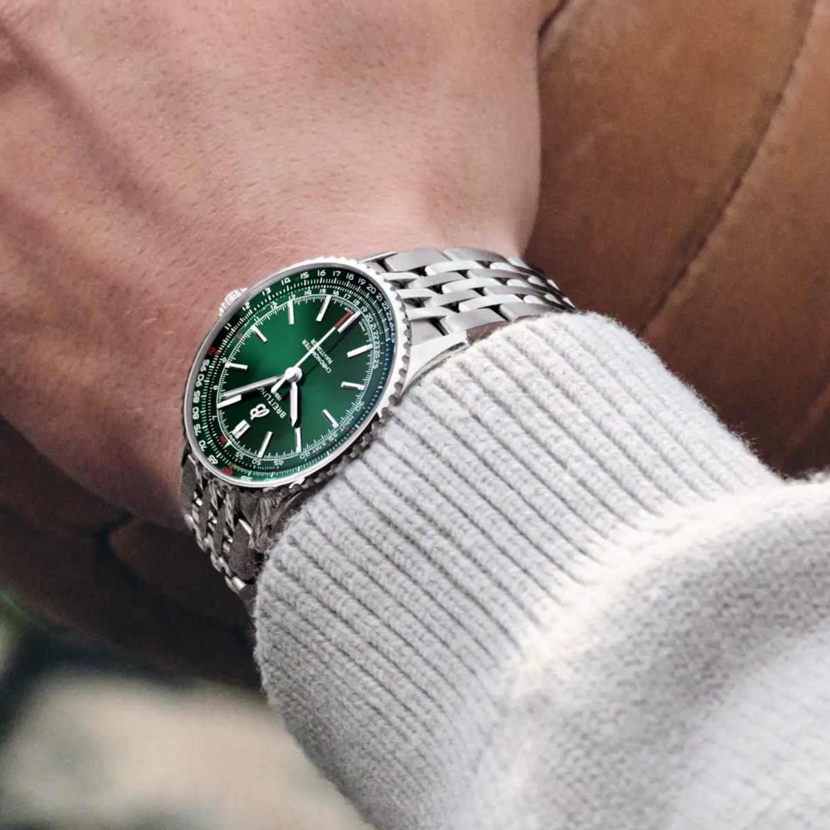 Breitling Navitimer Automatic green dial watch worn on wrist with stainless steel bracelet