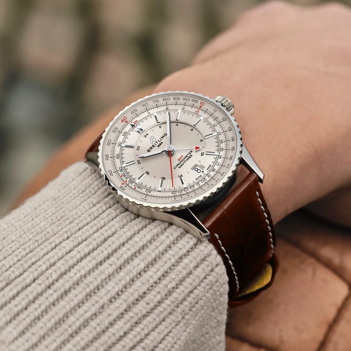 Breitling Navitimer GMT cream dial watch worn on wrist with brown leather strap