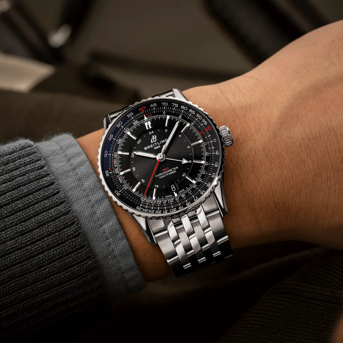 Breitling Navitimer GMT black dial watch worn on wrist with stainless steel bracelet