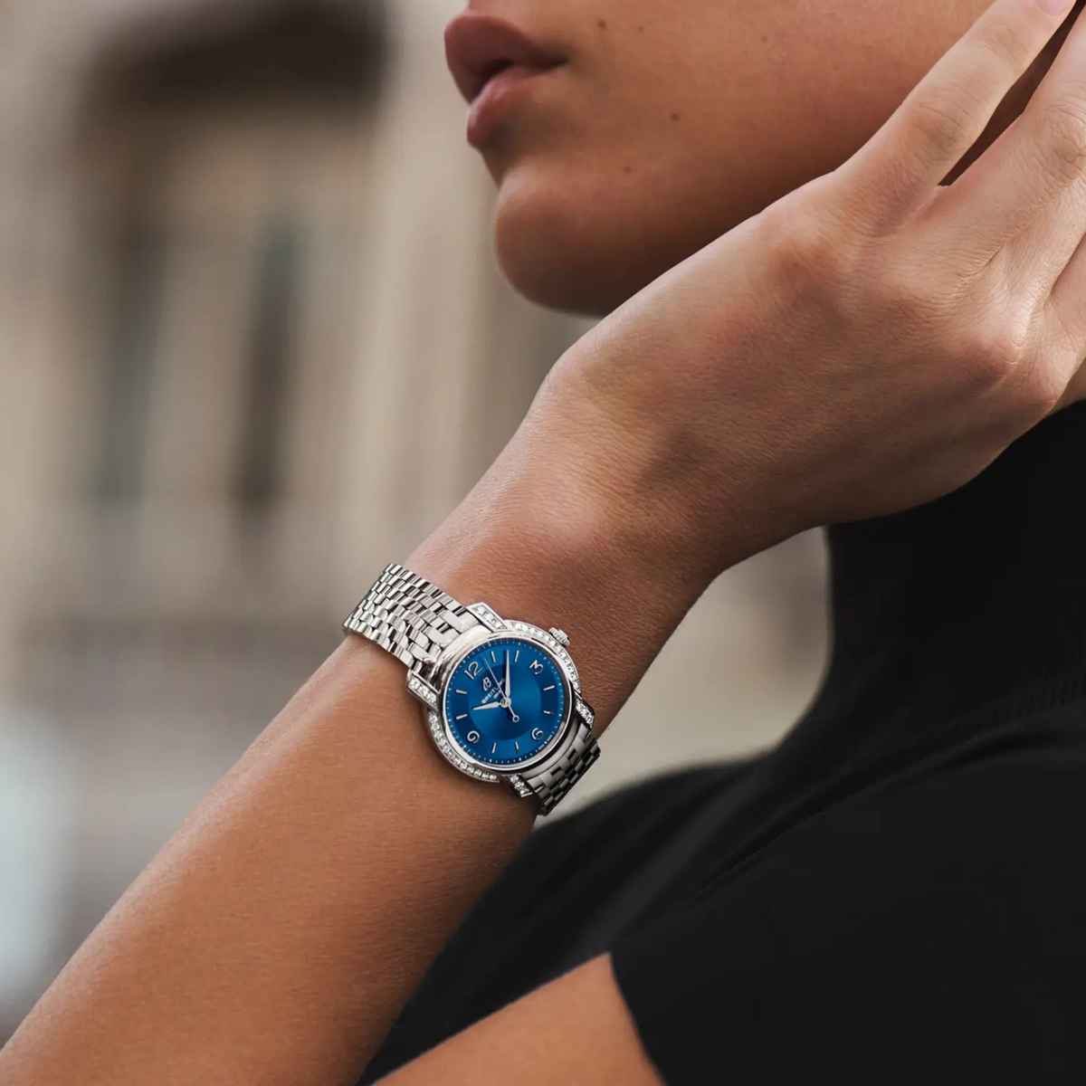 Breitling blue dial diamond bezel watch worn on wrist with stainless steel bracelet