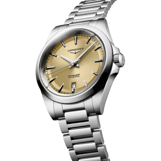close up of the Longines Conquest champagne sunray dial featuring polished silver hands, applied markers and date display

