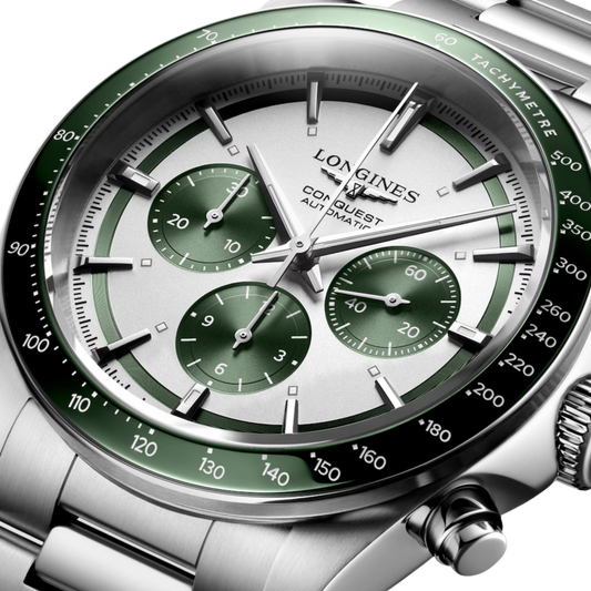 Longines Conquest chronograph watch worn on the wrist featuring a green tachymeter bezel and sporty stainless steel design
