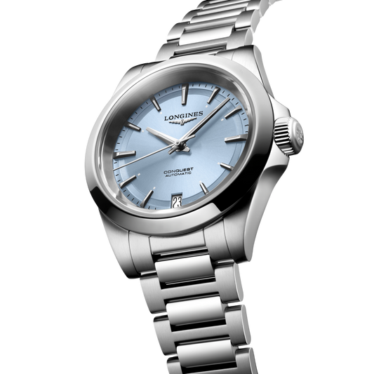 close up of the Longines Conquest ice blue sunray dial showing polished hour markers, silver hands and date window
