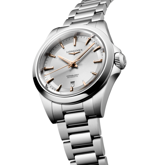 close up of the Longines Conquest silver dial showing rose gold tone hands, applied hour markers and date display

