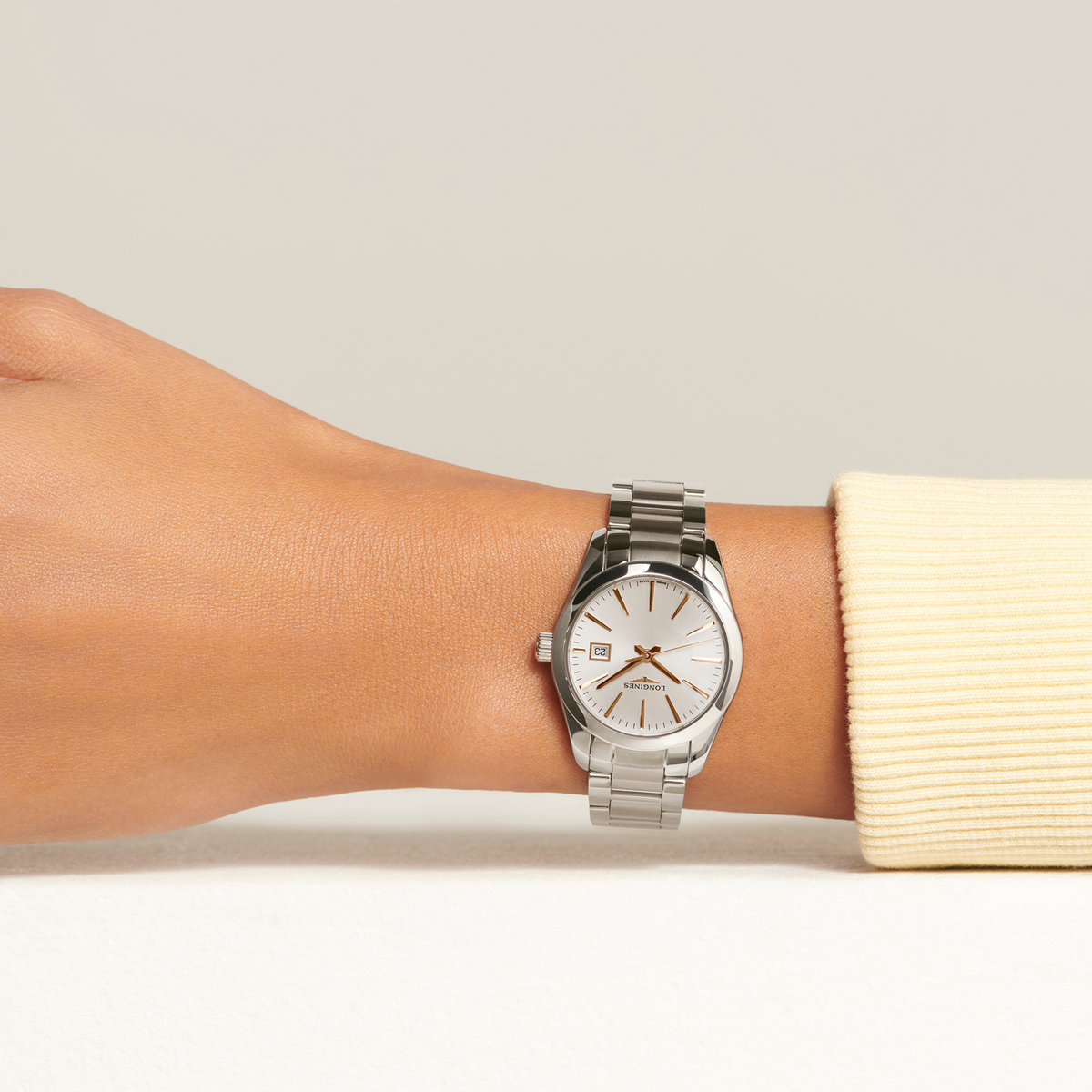 Longines Conquest stainless steel watch worn on the wrist with elegant silver dial and rose gold accents
