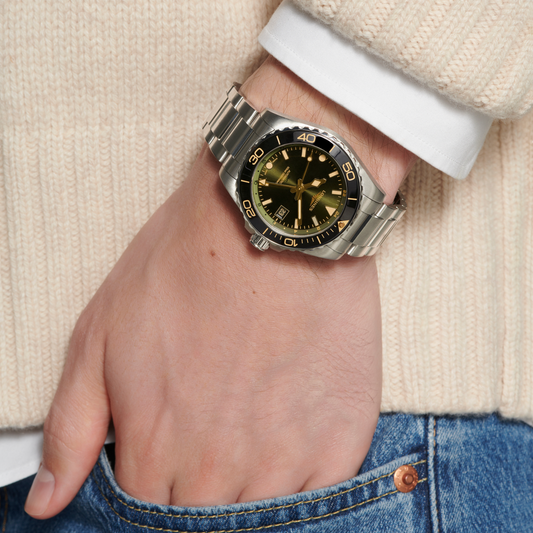 Longines HydroConquest GMT watch worn on the wrist featuring a green sunray dial, black bezel and sporty stainless steel bracelet

