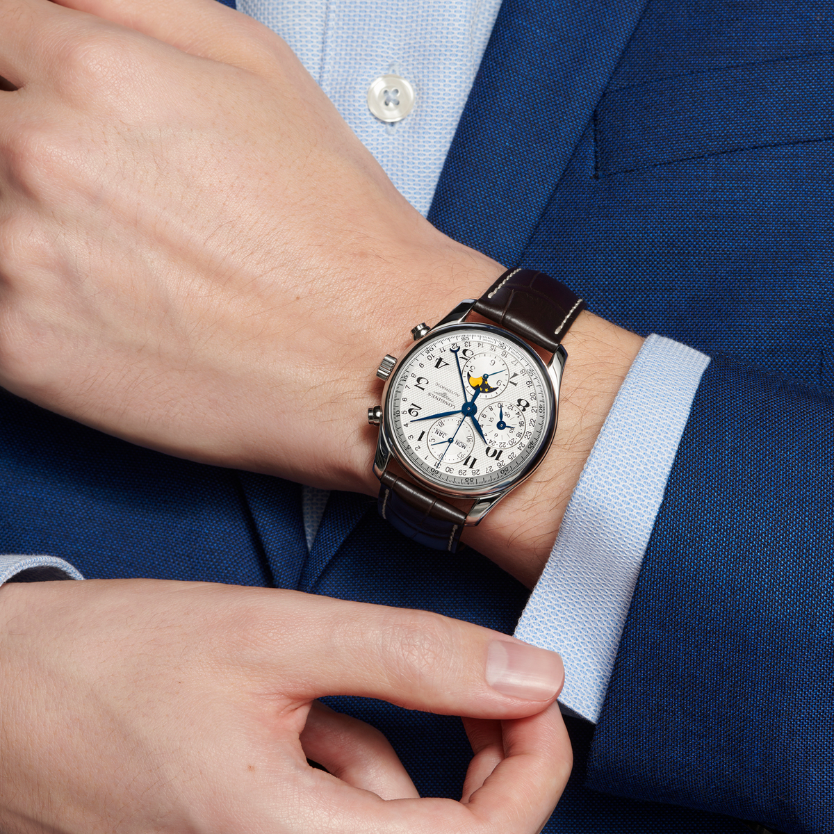lifestyle image of Longines Master Collection moonphase watch worn on a wrist showcasing the silver dial and brown leather strap
