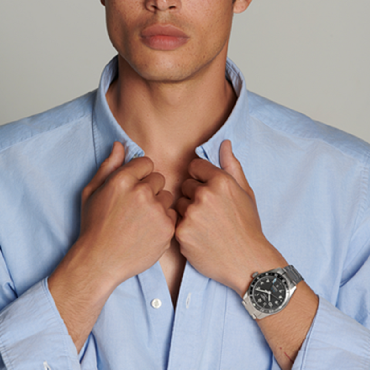 lifestyle image of Longines black dial GMT chronometer watch worn on a wrist showcasing the bidirectional bezel and sporty steel bracelet
