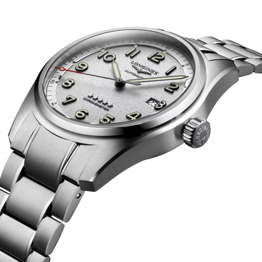 lifestyle image of Longines silver dial pilot-inspired watch worn on a wrist showcasing the red accent detail and sporty steel bracelet
