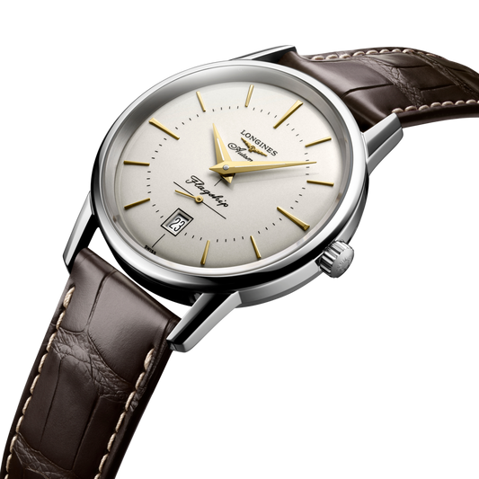 close up of the Longines Flagship Heritage dial featuring gold tone hour markers, automatic movement and date window at 6 o’clock
