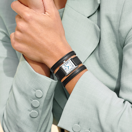 Longines DolceVita watch worn wrapped around the wrist with elegant black leather strap and silver rectangular case
