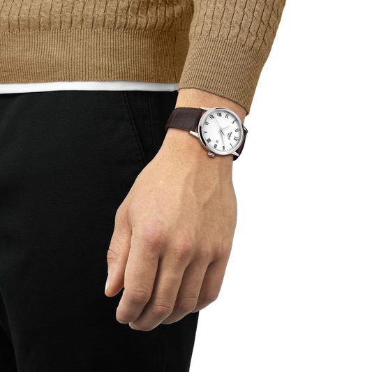 the watch worn on the wrist, showcasing the elegant white dial, slim stainless steel case, and brown crocodile-pattern leather strap suited to formal and everyday styling