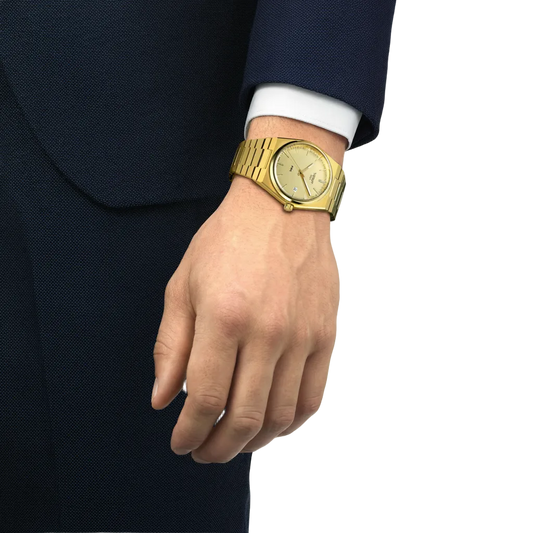 the watch worn on the wrist, showcasing the slim integrated bracelet, streamlined tonneau-shaped case, and monochromatic gold-tone finish suited to statement everyday styling