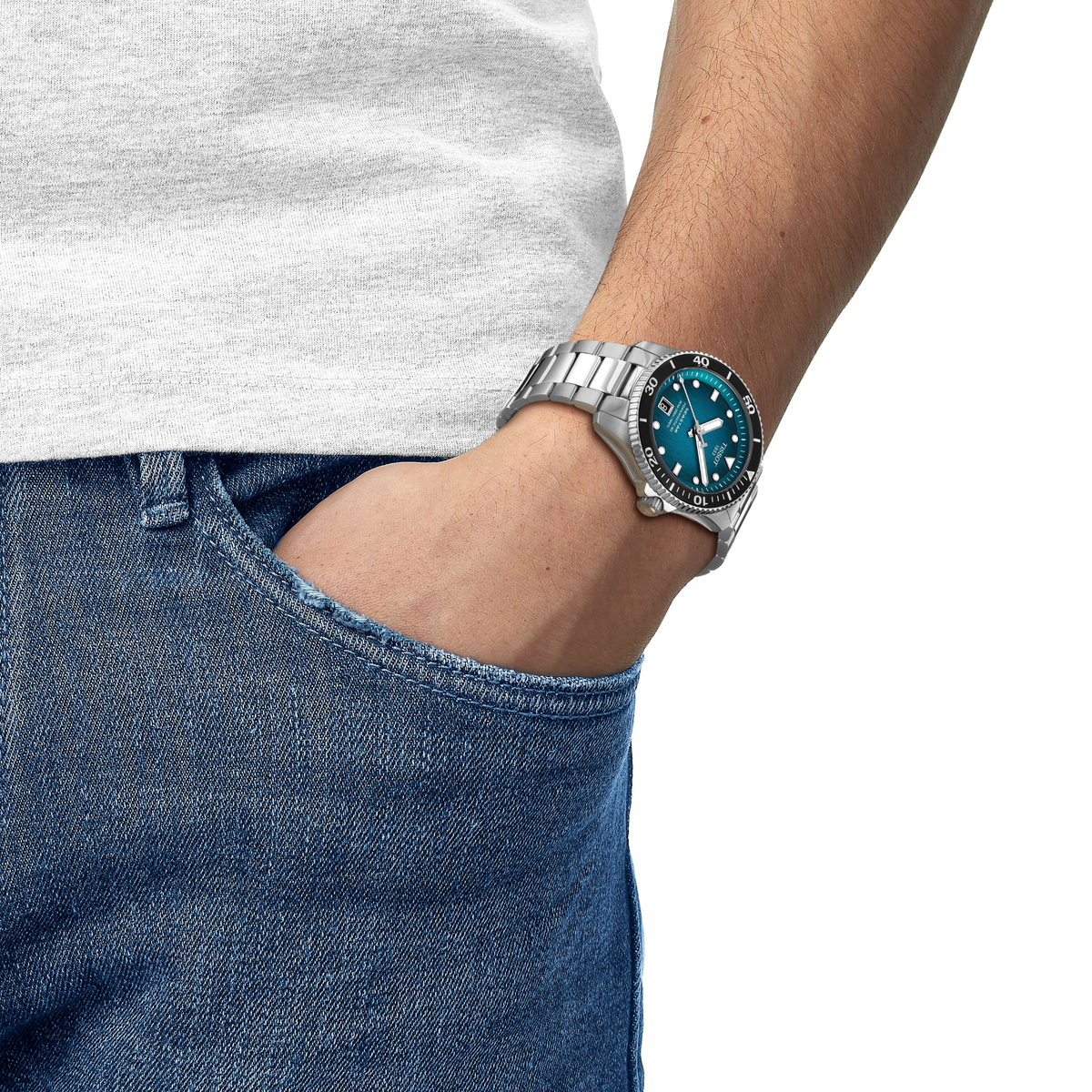 the watch worn on the wrist, showcasing the striking turquoise dial, robust diver styling, and comfortable stainless steel bracelet suited to active daily wear