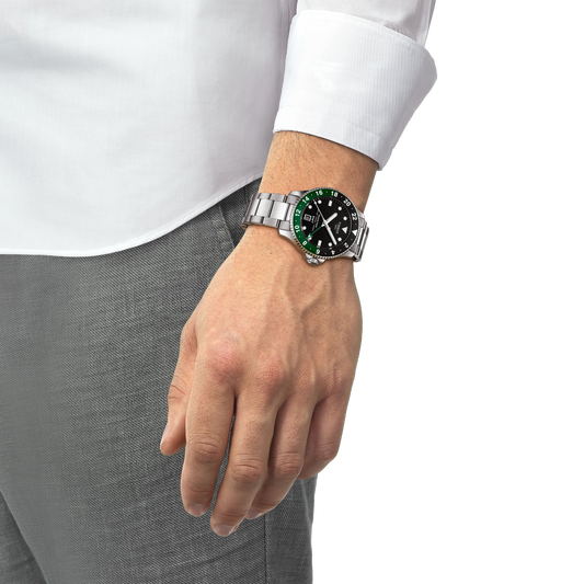 the watch worn on the wrist, showcasing the striking black dial, contrasting green GMT bezel accents, and robust stainless steel bracelet for an adventurous everyday look