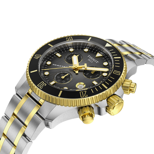 angled front-side image of the watch on the bracelet, revealing the depth of the black chronograph dial, gold-tone subdial detailing, luminous markers, and textured bezel design from a dynamic perspective