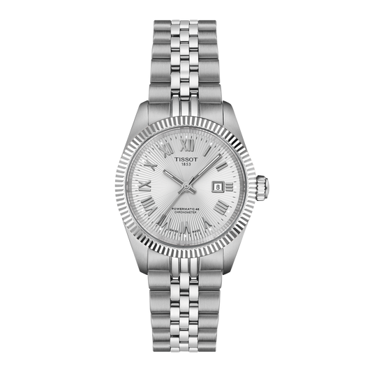 Tissot automatic stainless steel watch featuring a silver textured dial with engraved Roman numerals, fluted bezel detailing, and a date window at 3 o’clock, finished with a brushed and polished multi-link bracelet