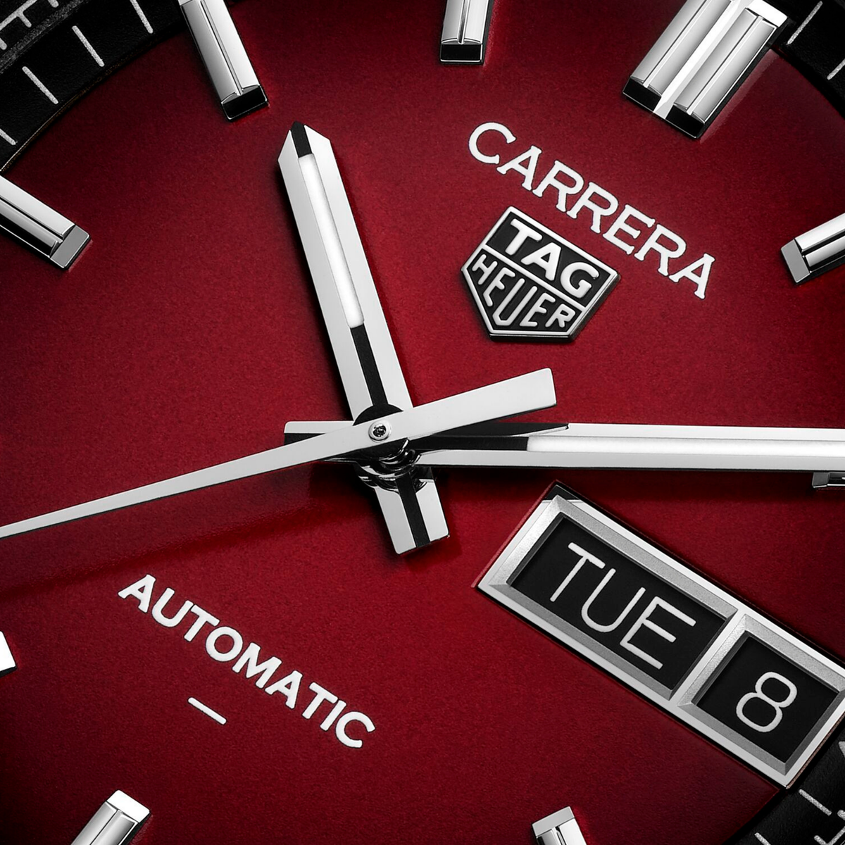 close-up of the red dial highlighting the sunray finish, black outer minute track, and clean, high-contrast hands and indexes
