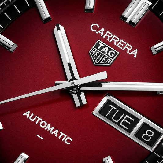 close-up of the red dial highlighting the sunray finish, black outer minute track, and clean, high-contrast hands and indexes