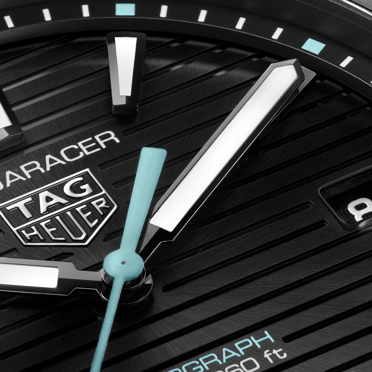 close-up of the black dial showcasing the horizontal stripe texture, luminous hour markers and hands, light blue seconds hand and date window at 3 o’clock