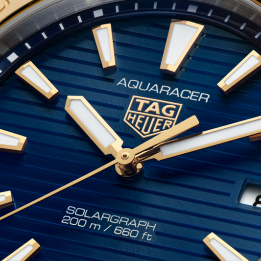 close-up of the blue dial showcasing the horizontal stripe texture, gold-tone hands and hour markers, central seconds hand and date window at 3 o’clock
