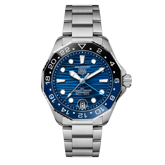 TAG Heuer Aquaracer GMT blue dial watch featuring a wave-pattern blue dial, bold luminous markers, and a bi-colour 24-hour bezel for tracking a second time zone, paired with a stainless steel bracelet