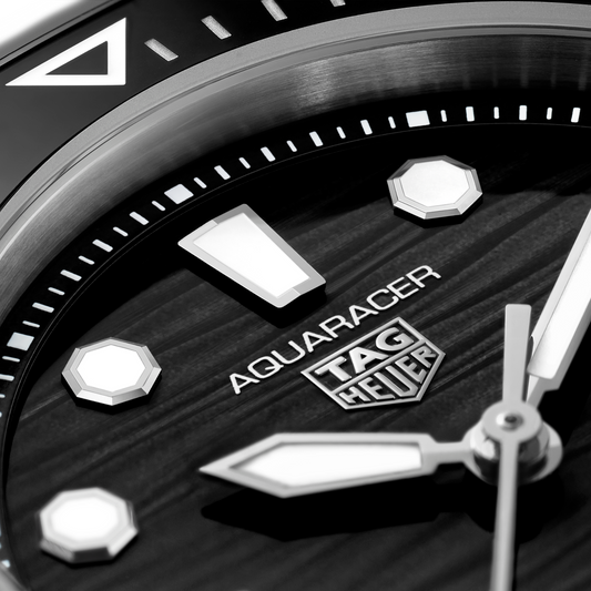 full view of the TAG Heuer Aquaracer highlighting the brushed steel bracelet and bold, angular case design
