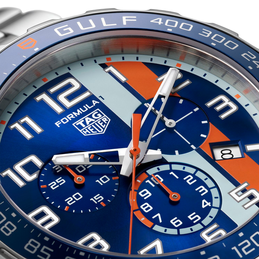 close-up of the blue dial showcasing the iconic Gulf colourway, bold Arabic numerals, orange accents, and tri-compax chronograph layout for sporty precision