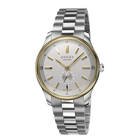 Gucci automatic stainless steel watch with a silver dial, gold-tone fluted bezel, small seconds sub-dial, and stainless steel bracelet shown in full front view