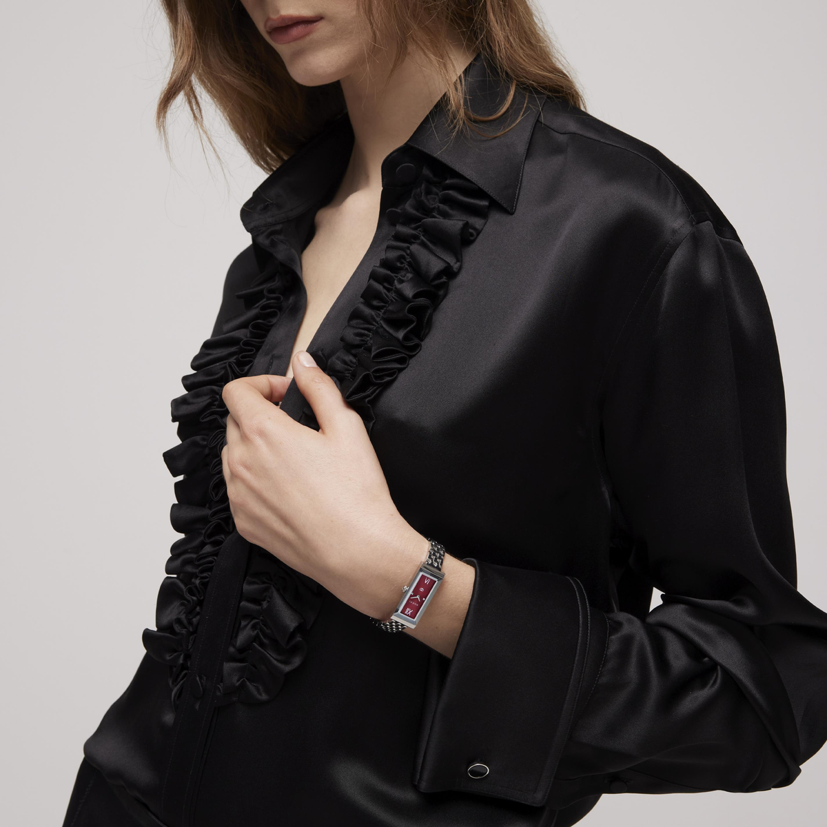 lifestyle image of the Gucci rectangular dial watch worn on the wrist, showcasing the polished stainless steel bracelet and rich burgundy dial styling for sophisticated everyday wear
