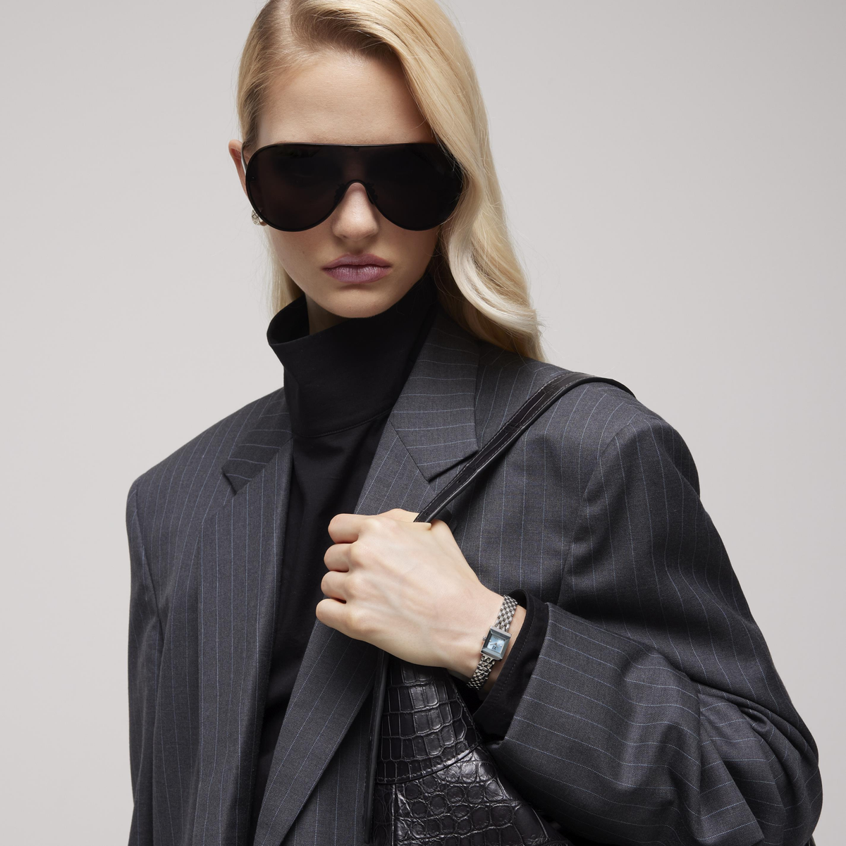 lifestyle image of the Gucci square dial watch worn on the wrist, showcasing the slim stainless steel bracelet and elegant light blue dial styling for everyday luxury wear
