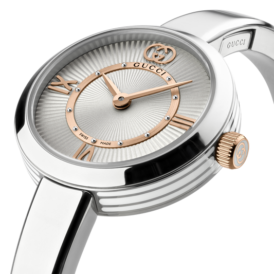 side profile of the Gucci watch highlighting the polished stainless steel bangle bracelet, slim rounded case, and rose gold-tone crown detailing
