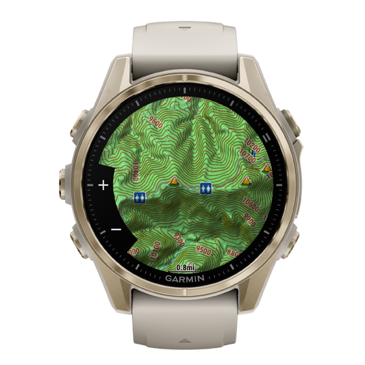 Garmin Fenix multisport GPS smartwatch with cream performance strap, gold-tone case, and advanced fitness dashboard display shown in angled front view