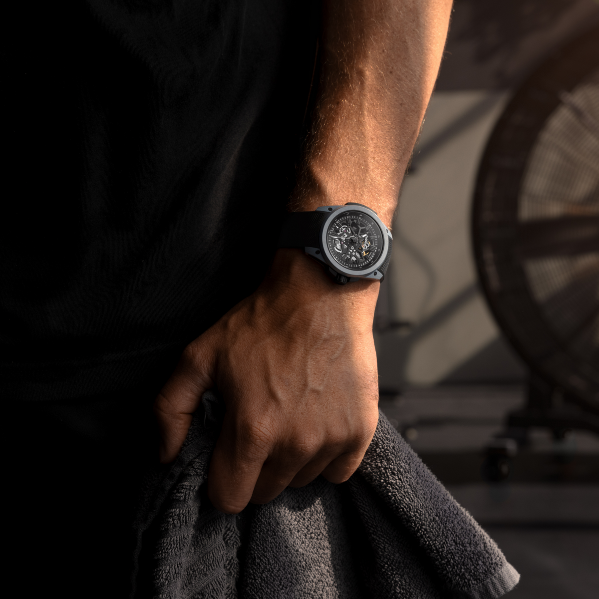 Luxury Norqain skeleton watch with a dark grey case, black rubber strap, open-worked movement display and contemporary Swiss sports watch design with a stealth-inspired aesthetic.