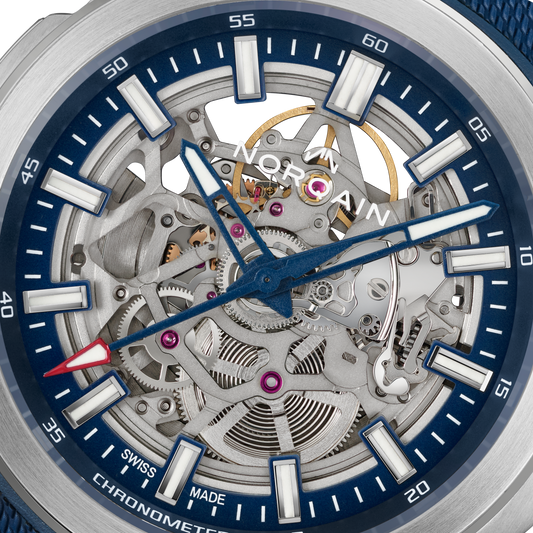 Close-up detail of the Norqain Independence Skeleton Blue Automatic Watch featuring the intricate open-worked movement, visible gears and jewels, blue accents, chronometer certification and Swiss-made craftsmanship.