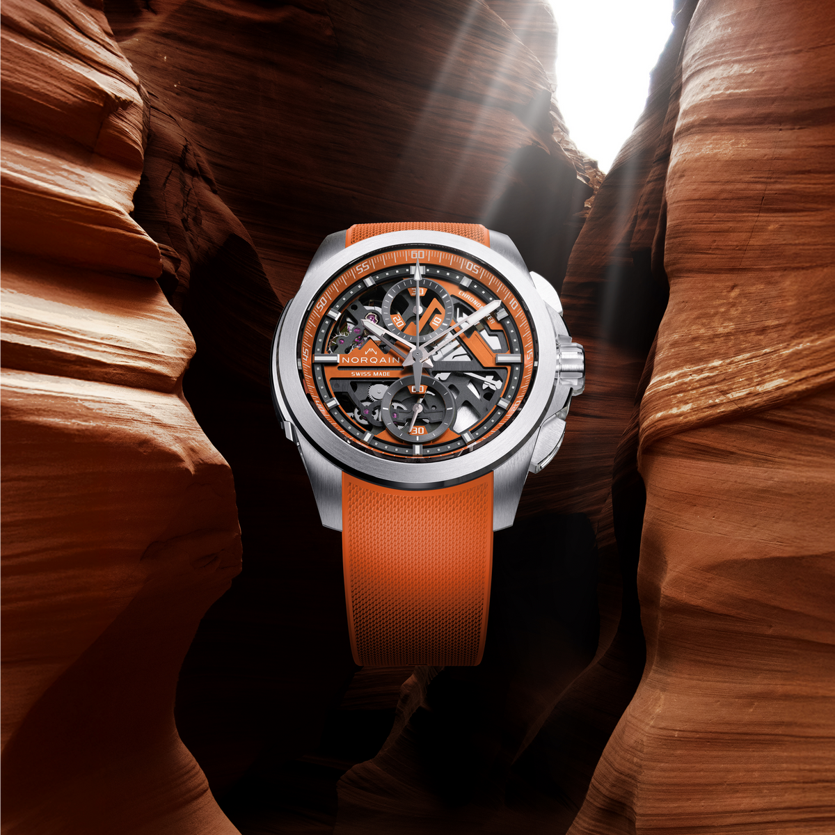 Detailed view of the Norqain automatic skeleton watch with orange accents, transparent dial construction, chronograph functionality and high-performance Swiss watchmaking design.