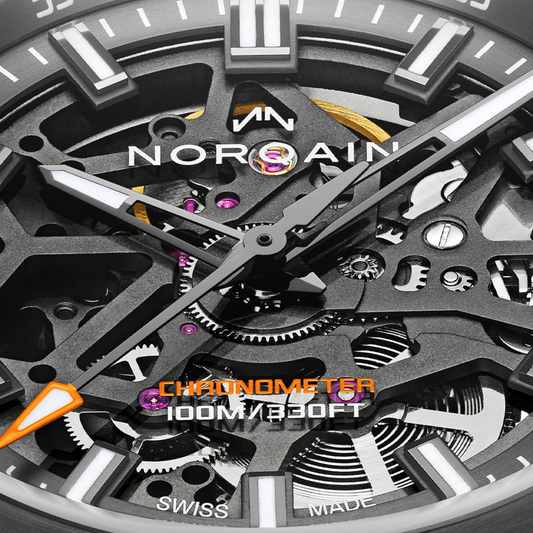 Close-up of the Norqain skeleton automatic watch showcasing exposed mechanical components, grey and black movement architecture, luminous hands and a rugged green rubber strap.