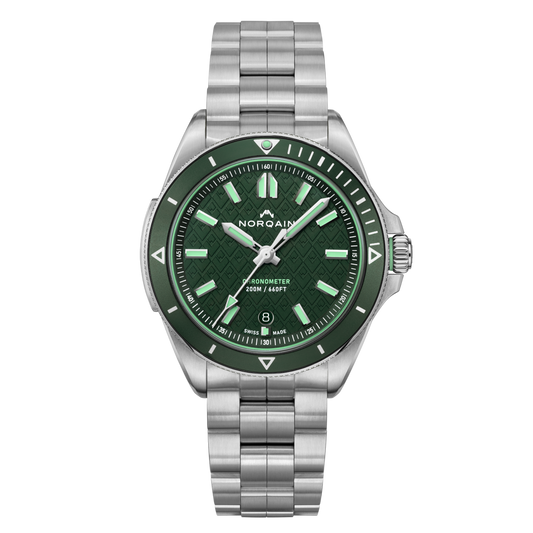 Front view of the Norqain Adventure Sport 42mm Green Dial Watch featuring a textured green dial, matching green bezel, luminous baton hour markers and stainless steel bracelet.
