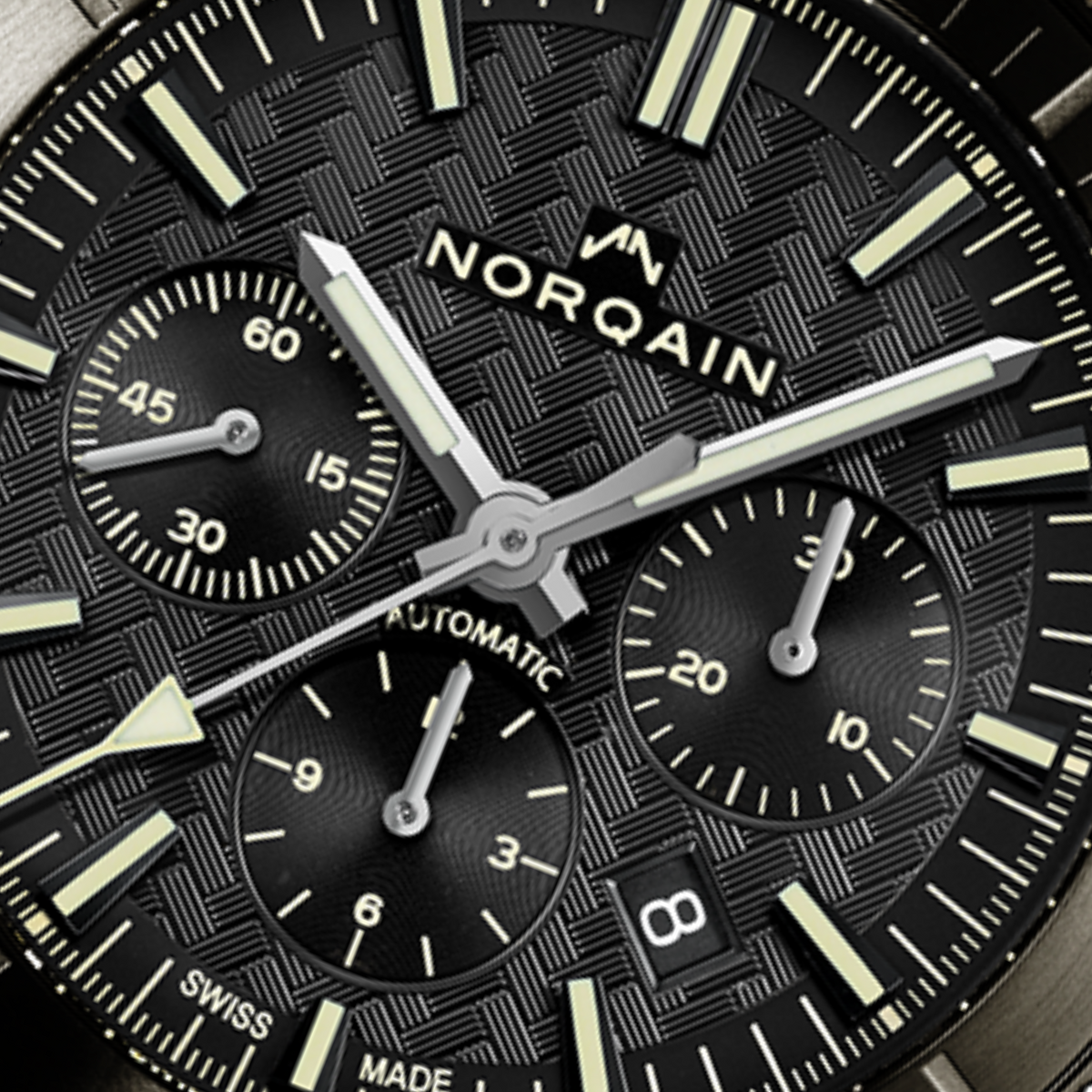 Close-up detail of the Norqain Adventure Sport Chronograph with black textured dial, contrasting sub-dials, Super-LumiNova hands and markers, date display and precision Swiss automatic movement styling.