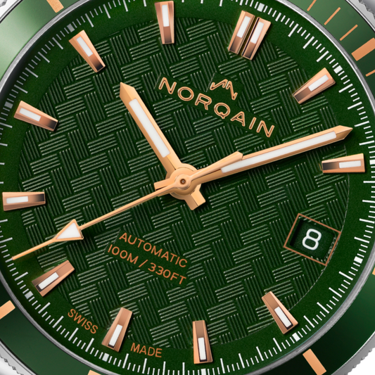 Close-up detail of the Norqain Independence Green Dial Automatic Watch featuring the distinctive geometric dial texture, rose gold-tone accents, date display at 3 o’clock and Swiss-made automatic movement styling.